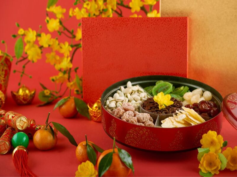 Tách trà, mứt Tết, bánh kẹo, trái cây bày biện trên bàn tiếp khách